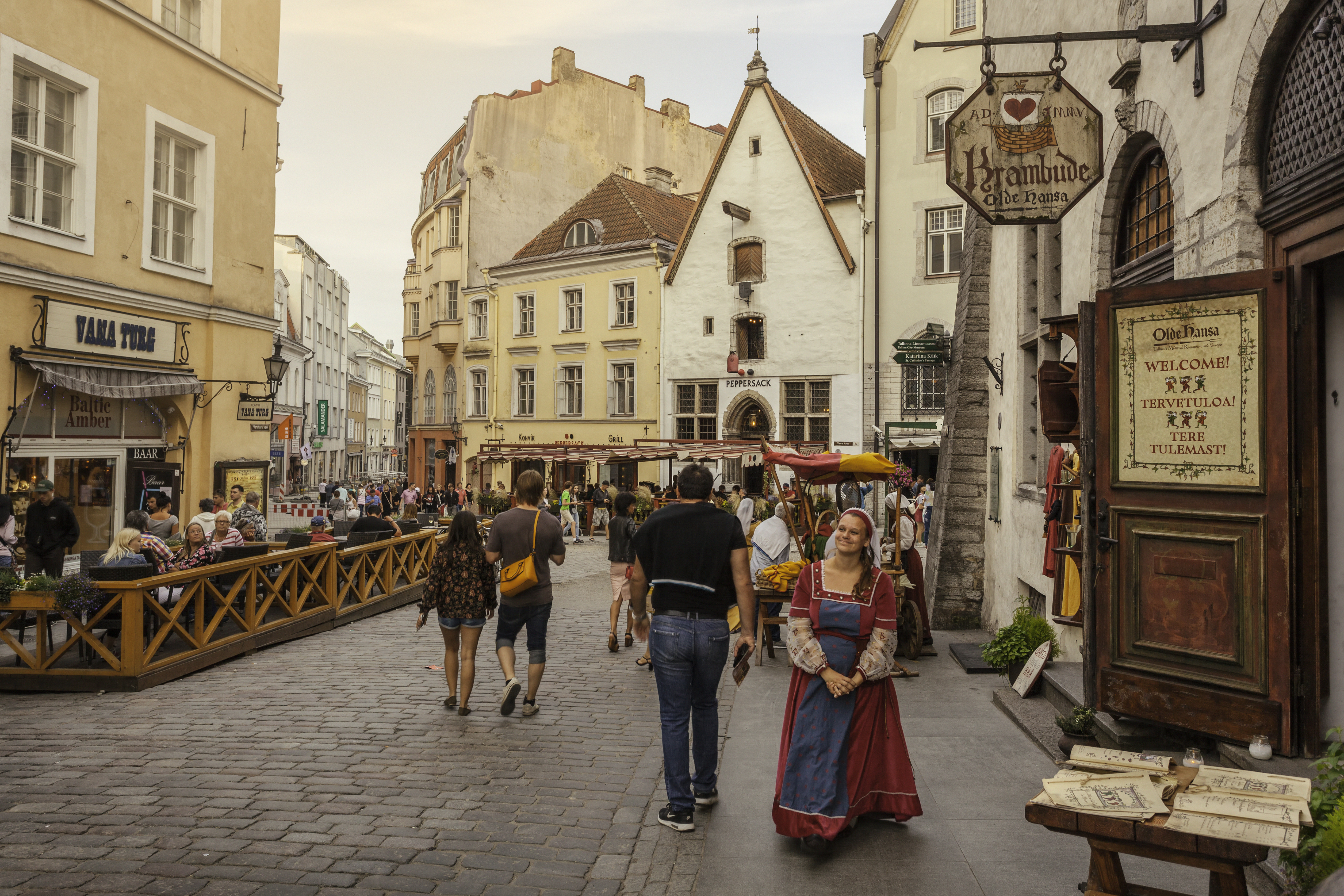 A woman greets tourists outside a restaurant in Tallinn's old town